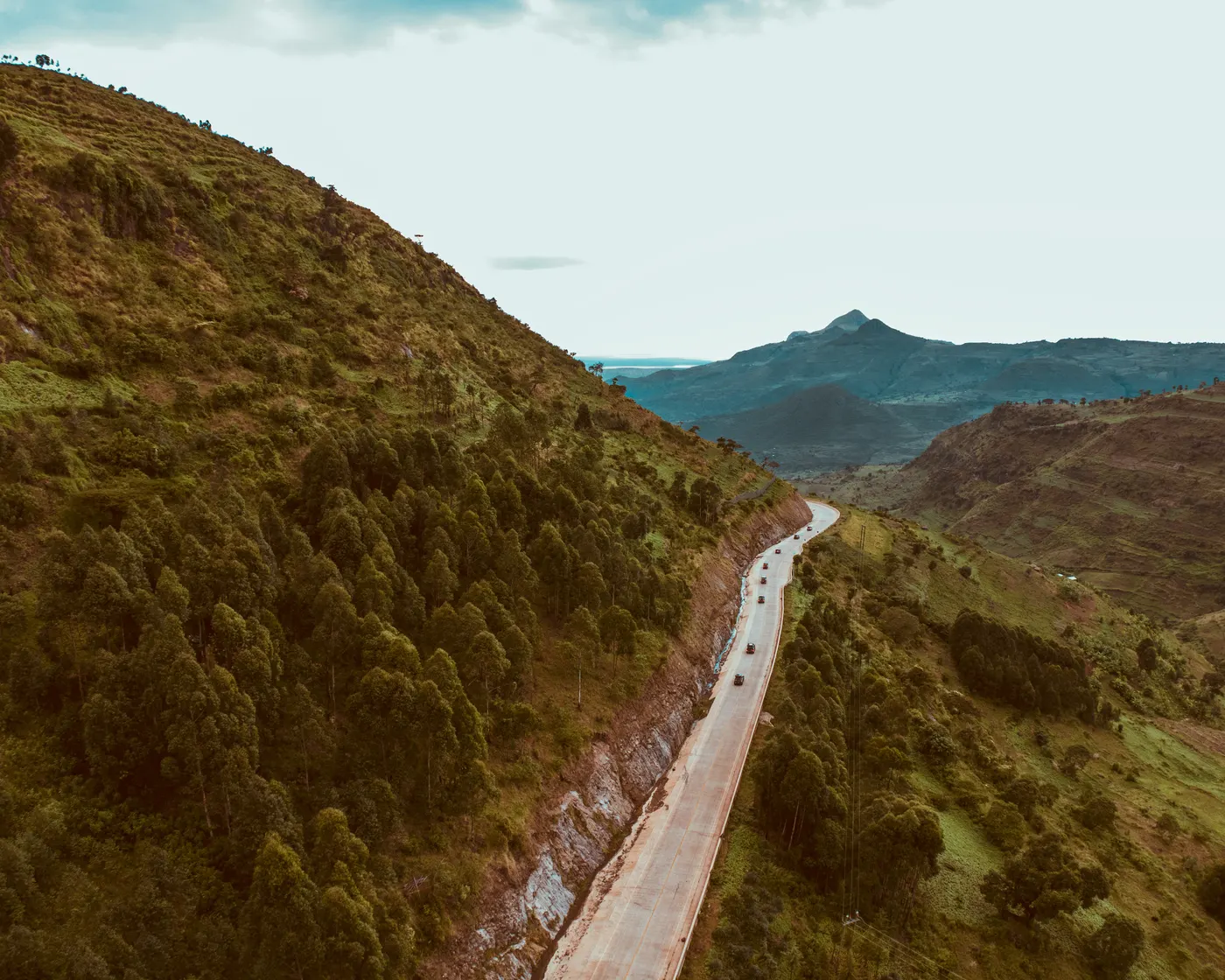Winding road climbing between grassy highland slopes