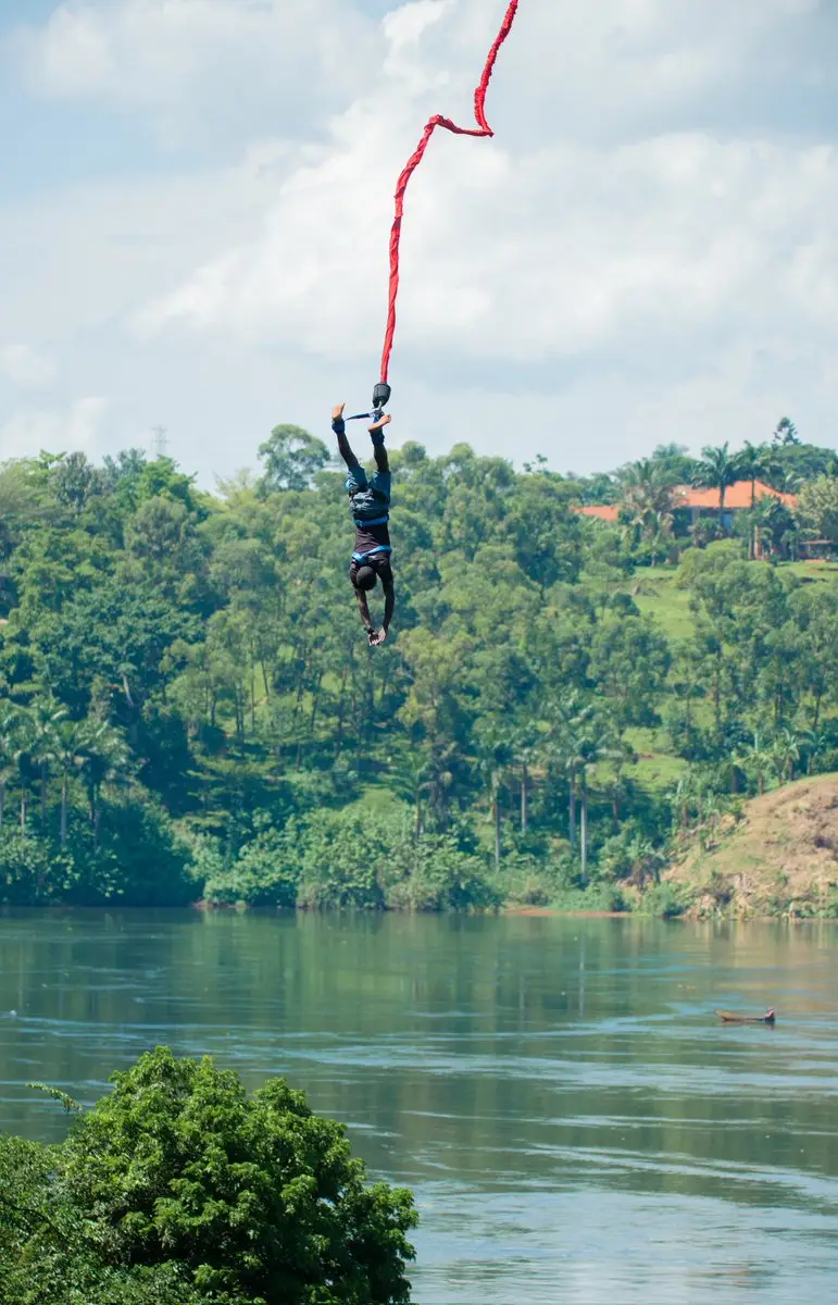 Person suspended from a bungee cord above a river