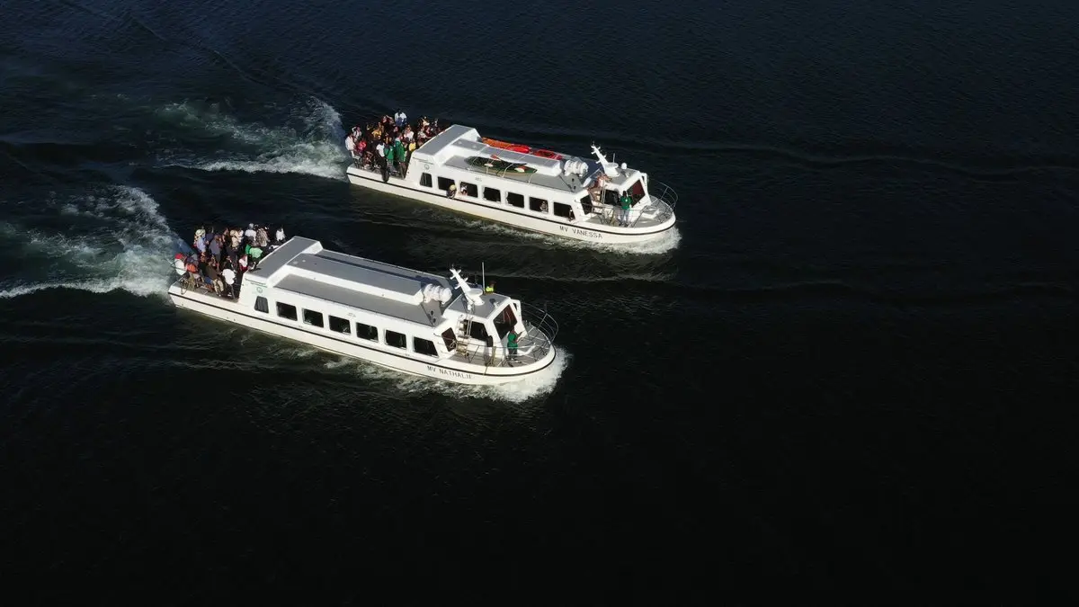 Two passenger boats travelling across dark river water