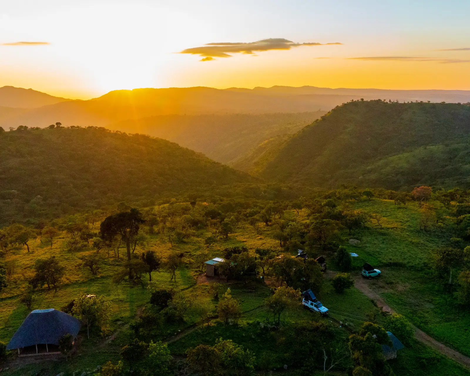 Evening sunlight falling across wooded hills and a valley