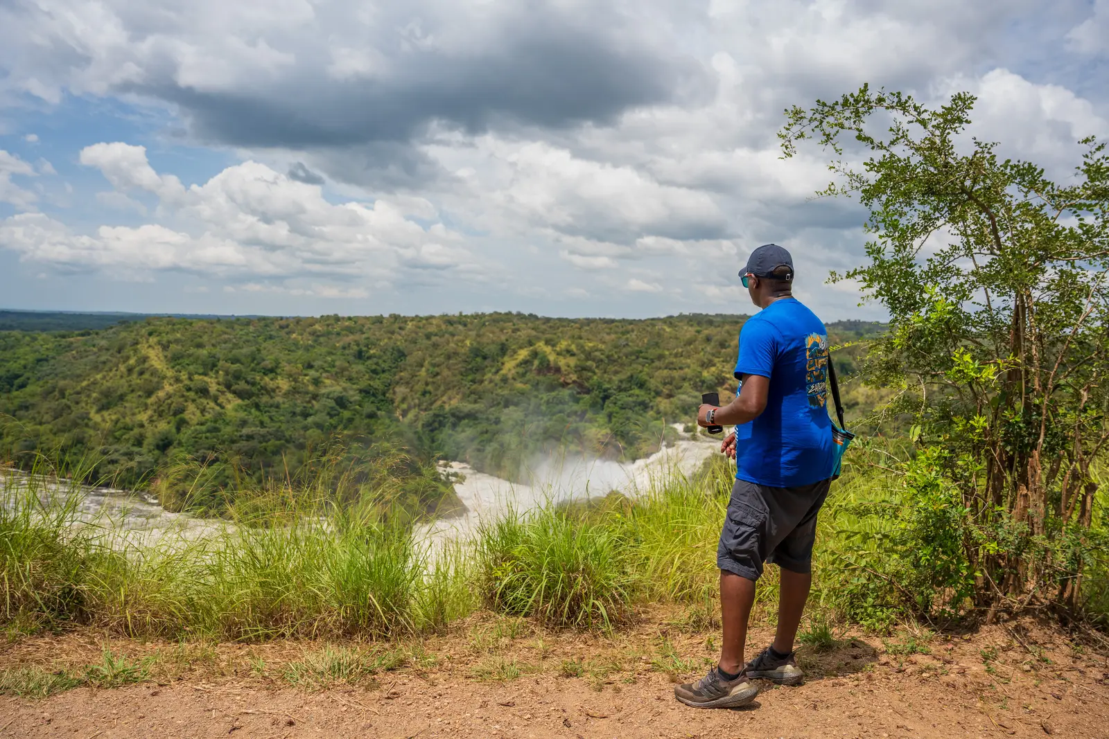 Visitor looking out over a river valley from a grassy viewpoint