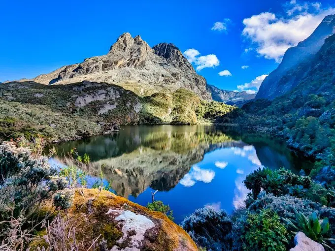 Highland lake reflecting the surrounding mountains and sky